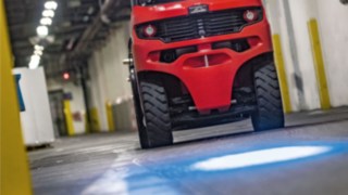 Un chariot frontal Linde avec BlueSpot projette un point d’avertissement bleu sur le sol