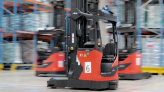 Trois chariots à mât rétractable automatisés de la gamme R-MATIC Linde en service.