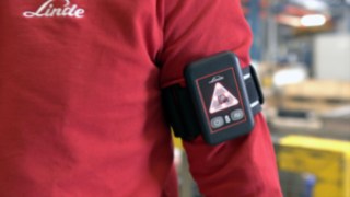Der Distance Beeper von Linde am Arm eines Beschäftigten Der Distance Beeper von Linde am Arm eines Beschäftigten