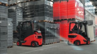 Le chariot élévateur Linde avec éclairage LED entre dans l’entrepôt de stockage avec sa charge