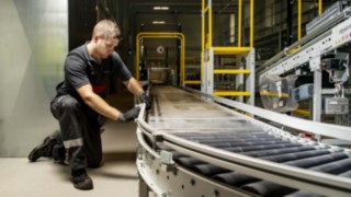 Un technicien de service de Linde répare un convoyeur à rouleaux