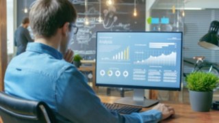 Person analysiert Daten an einem Computer