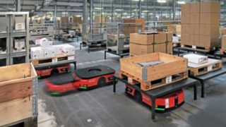 Mehrere automatisierte Plattformfahrzeuge C-MATIC von Linde MH bewegen Waren im Lager von ABS Safety. 