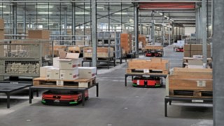 Automatisierte Plattformfahrzeuge C-MATIC von Linde MH bewegen Kisten und Paletten durch das Lager bei ABS Safety,