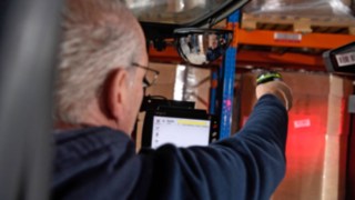 Ein Mitarbeiter von Schröder scannt den Barcode an der WareEin Mitarbeiter von Schröder scannt den Barcode an der Ware.Ein Mitarbeiter von Schröder scannt den Barcode an der Ware